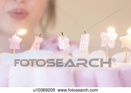 Girl blowing out candles on candies View Large Photo Image Stock Photo - Girl blowing out candles on candies. Fotosearch