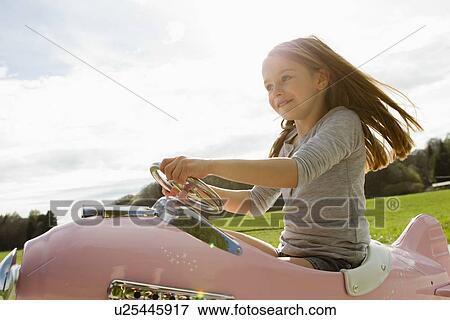 Stock Photo - Girl driving toy airplane in field. Fotosearch
