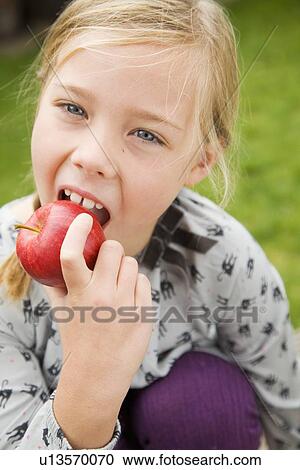 Girl eating fruit outdoors View Large Photo Image Stock Image - Girl eating fruit outdoors. Fotosearch