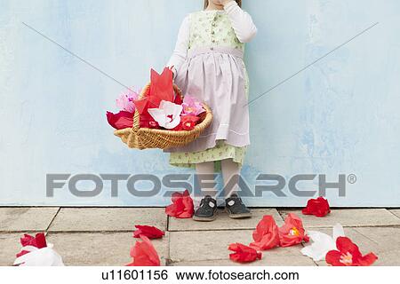 Stock Photograph - Girl holding basket of paper flowers. Fotosearch