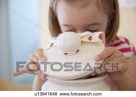 Girl opening cookie jar in kitchen View Large Photo Image Stock Photo - Girl opening cookie jar in kitchen. Fotosearch