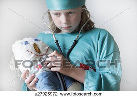Girl playing doctor with doll View Large Photo Image Stock Image - Girl playing doctor with doll. Fotosearch