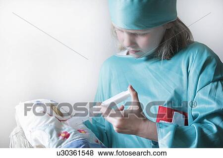 Stock Photo - Girl playing doctor with doll. Fotosearch