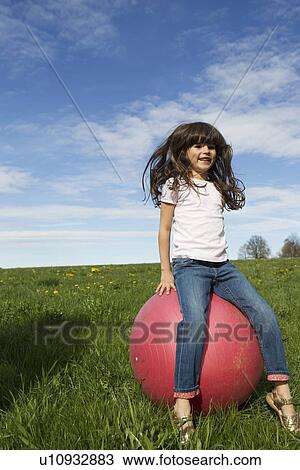 Girl playing on bouncy ball outdoors View Large Photo Image Stock Image - Girl playing on bouncy ball outdoors. Fotosearch