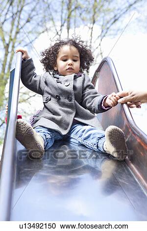 Girl playing on slide in playground View Large Photo Image Stock Image - Girl playing on slide in playground. Fotosearch