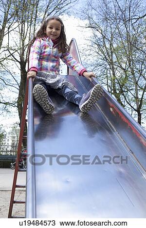 Girl playing on slide in playground View Large Photo Image Stock Image - Girl playing on slide in playground. Fotosearch
