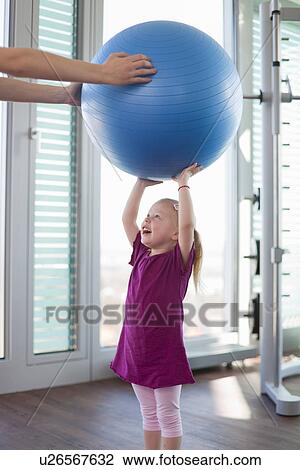 Girl playing with exercise ball in gym View Large Photo Image Stock Image - Girl playing with exercise ball in gym. Fotosearch