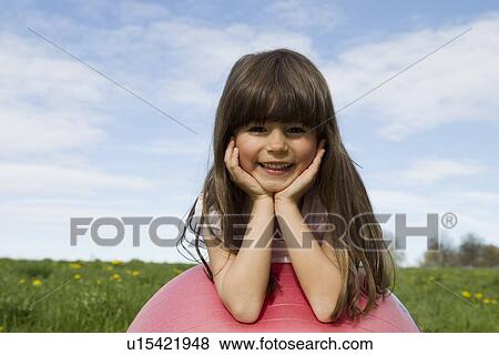 Girl sitting on bouncy ball outdoors View Large Photo Image Stock Photo - Girl sitting on bouncy ball outdoors. Fotosearch