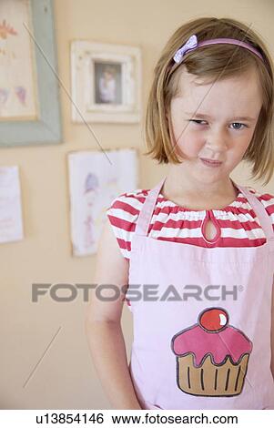 Girl wearing apron in kitchen View Large Photo Image Stock Photograph - Girl wearing apron in kitchen. Fotosearch