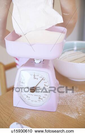 Girl weighing ingredients in kitchen View Large Photo Image Stock Image - Girl weighing ingredients in kitchen. Fotosearch