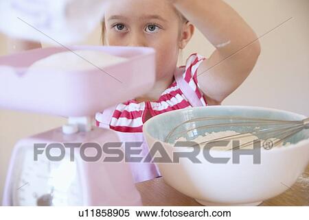 Girl weighing ingredients in kitchen View Large Photo Image Stock Photography - Girl weighing ingredients in kitchen. Fotosearch