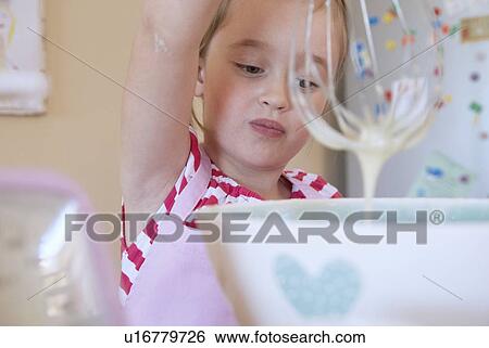 Stock Photograph - Girl whisking in kitchen. Fotosearch