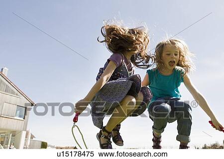 Girls jumping rope together outdoors View Large Photo Image Stock Photography - Girls jumping rope together outdoors. Fotosearch