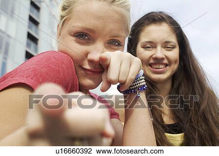 Stock Image - Girls making faces on city street. Fotosearch
