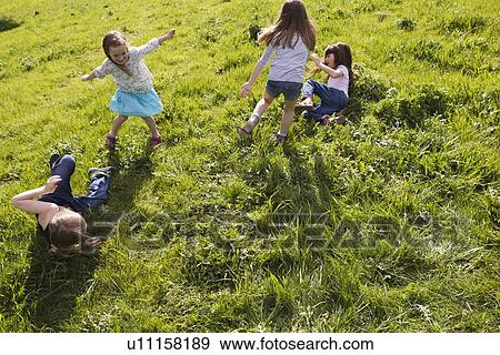 Stock Photo - Girls playing together in field. Fotosearch
