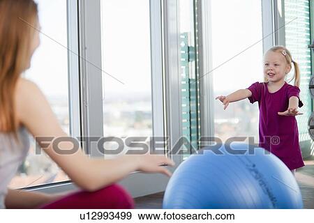 Stock Photo - Girls playing with exercise ball in gym. Fotosearch