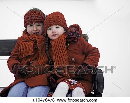 Girls sitting on bench in snow View Large Photo Image Stock Photo - Girls sitting on bench in snow. Fotosearch