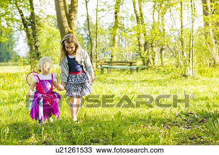 Stock Image - Girls walking together in field. Fotosearch