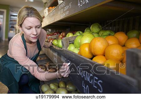 Grocer labeling produce for sale View Large Photo Image Picture - Grocer labeling produce for sale. Fotosearch