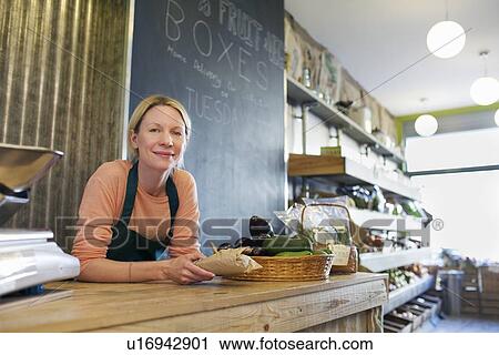 Grocer working behind counter at store View Large Photo Image Stock Image - Grocer working behind counter at store. Fotosearch