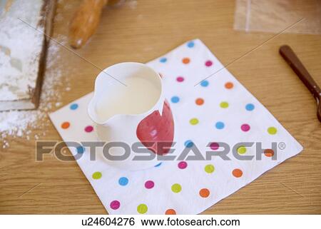 Stock Photograph - Jug of milk on towel in kitchen. Fotosearch