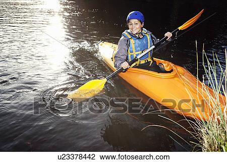 Kayaker rowing in still lake View Large Photo Image Stock Image - Kayaker rowing in still lake. Fotosearch