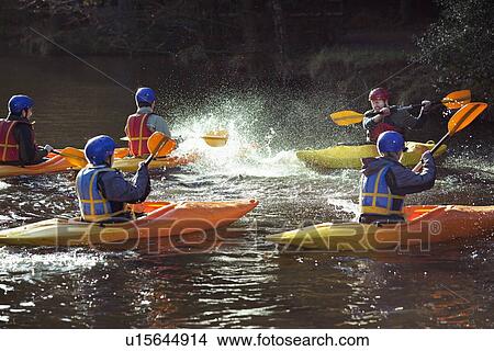 Picture - Kayakers rowing together on still lake. Fotosearch