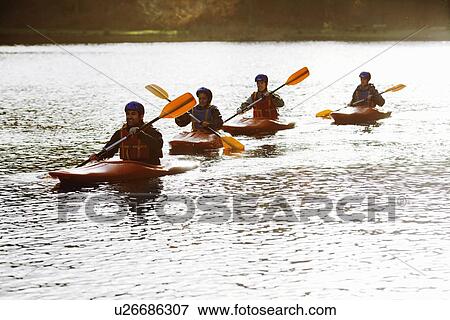 Kayakers rowing together on still lake View Large Photo Image Stock Photo - Kayakers rowing together on still lake. Fotosearch