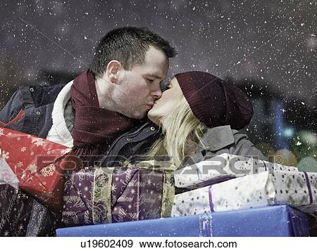 Kissing couple with Christmas gifts View Large Photo Image Stock Photo - Kissing couple with Christmas gifts. Fotosearch