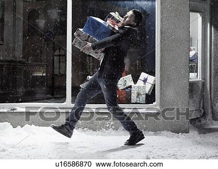 Man carrying Christmas gifts in snow View Large Photo Image Stock Image - Man carrying Christmas gifts in snow. Fotosearch
