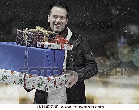 Man carrying Christmas gifts in snow View Large Photo Image Stock Image - Man carrying Christmas gifts in snow. Fotosearch