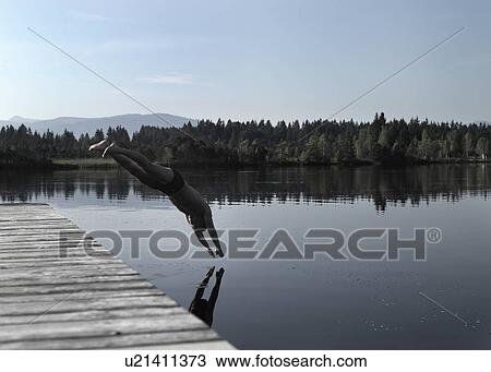 Stock Image - Man diving into still lake. Fotosearch