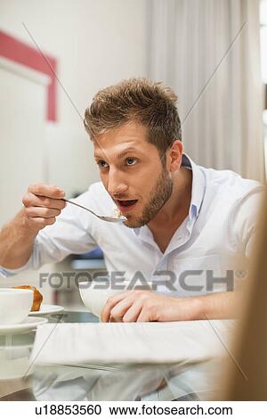 Man eating breakfast at table View Large Photo Image Stock Image - Man eating breakfast at table. Fotosearch