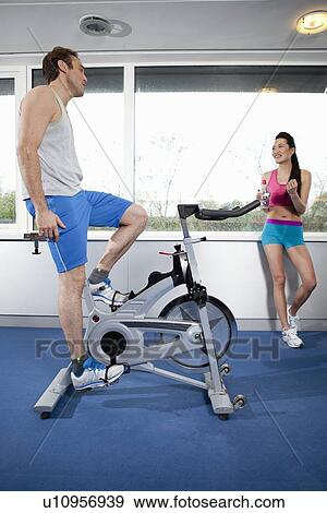 Man pedaling stationery bicycle in gym View Large Photo Image Stock Photo - Man pedaling stationery bicycle in gym. Fotosearch