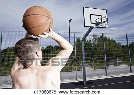 Stock Photography - Man playing basketball on urban court. Fotosearch