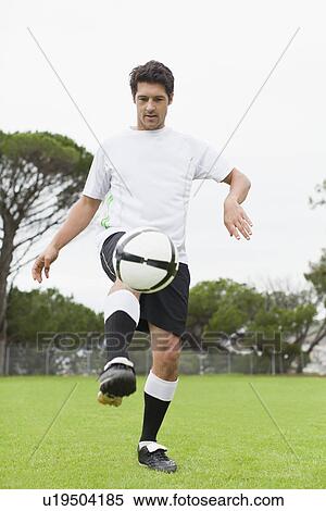 Man playing with soccer ball in field View Large Photo Image Stock Photography - Man playing with soccer ball in field. Fotosearch