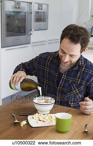 Man pouring milk for cereal View Large Photo Image Stock Image - Man pouring milk for cereal. Fotosearch