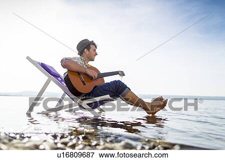 Man relaxing in lawn chair in creek View Large Photo Image Stock Photo - Man relaxing in lawn chair in creek. Fotosearch