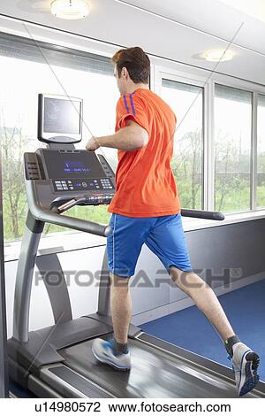 Man running on treadmill in gym View Large Photo Image Stock Image - Man running on treadmill in gym. Fotosearch