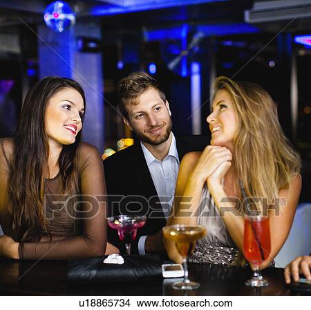Man talking to women at bar View Large Photo Image Picture - Man talking to women at bar. Fotosearch