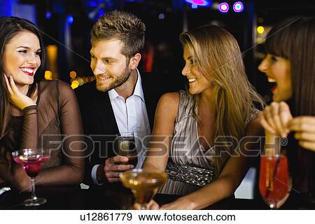 Man talking to women at bar View Large Photo Image Stock Photo - Man talking to women at bar. Fotosearch