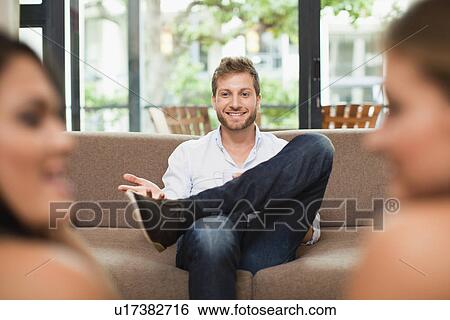 Man talking to women on sofa View Large Photo Image Stock Photograph - Man talking to women on sofa. Fotosearch