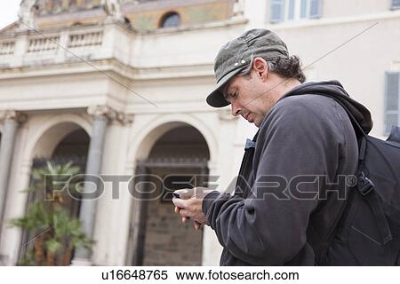 Man using cell phone on city street View Large Photo Image Stock Photography - Man using cell phone on city street. Fotosearch