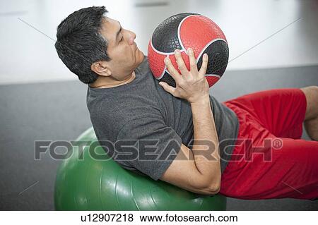 Man using exercise ball in gym View Large Photo Image Stock Photo - Man using exercise ball in gym. Fotosearch