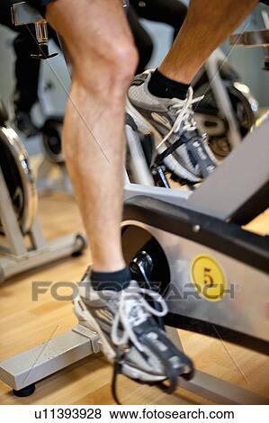 Stock Photo - Man using spin machine in gym. Fotosearch