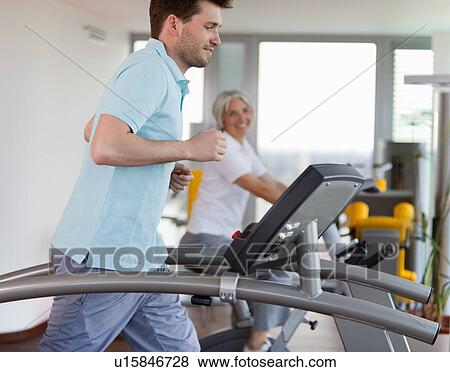 Stock Photo - Man using treadmill in gym. Fotosearch