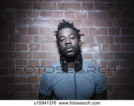 Stock Photograph - Man wearing headphones around neck. Fotosearch