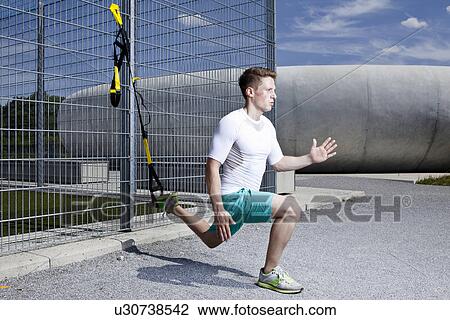 Stock Image - Man working out in industrial area. Fotosearch