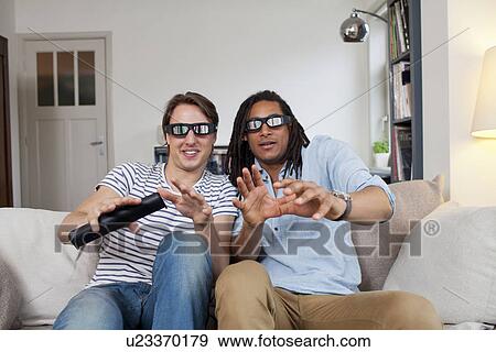 Stock Photo - Men watching 3D television together. Fotosearch