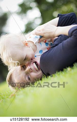 Stock Image - Mother and baby playing in grass. Fotosearch